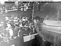 Wood (in white uniform at lower left) attends the christening of the submarine USS&nbsp;O-1, 9 July 1918.