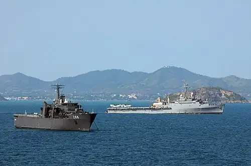 RSS Resolution at anchor in the Gulf of Thailand, with USS Denver passing behind during Cobra Gold '11.