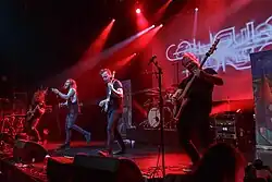 Four male musicians performing on stage