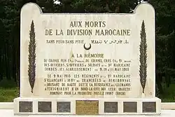 White rectangular stone memorial. It is inscribed "AUX MORTS DE LA DIVISION MAROCAINE", with other dedicatory messages in French, and with one phrase in Arabic.