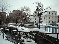 Pełcznica river and the historic Pod Lwami House ("Under the Lions") on the right, in wintertime