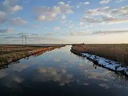 Drentsche Diep seen from the Polderpad with polder mill De Biks in the background
