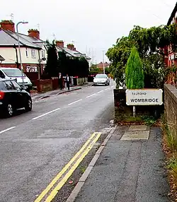 A suburban street with a boundary sign saying "Telford Wombridge"