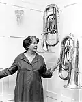 Dame Zara Bate, wife of Harold Holt, with the two euphoniums she hung at The Lodge, 1966
