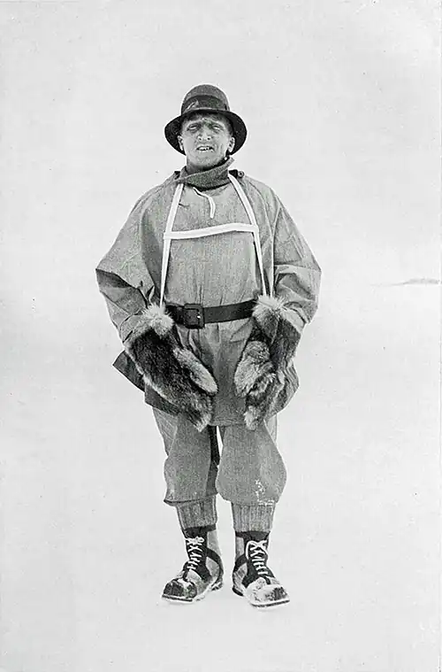 Full-length portrait of a man in period polar gear amid featureless snow