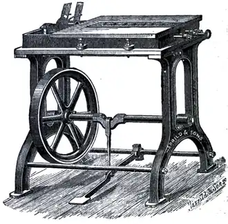 Cross-hatched drawing of a table-like bench with an inner wheel connected by axle to a floor peddle.
