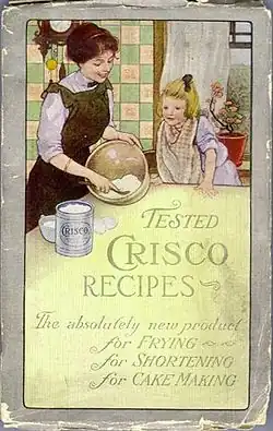 Cover of the 1912 Crisco Cookbook: In a kitchen, a woman mixes something in a bowl while a girl watches