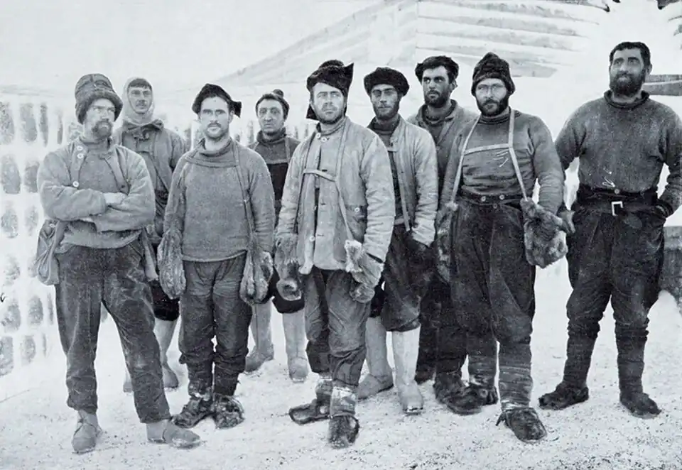 Photo of nine men standing outside in cold-weather gear