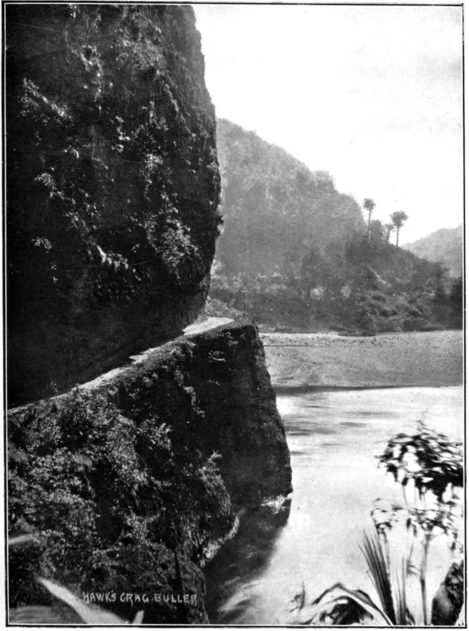 Hawk's Crag, Buller Gorge - a narrow track carved into a hill side with a shear drop into a river, and a stony beach and bush-covered hills in the background