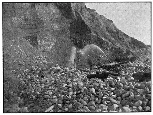 Aftermath of a hill that had been washed out for gold. There are numerous rocks at the bottom.