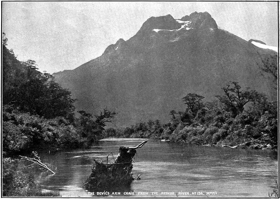 A lake edged with forest and with a tall mountain behind