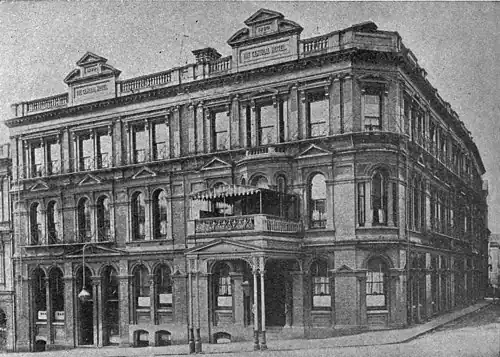 Three story building on a corner with a verandah over the entrance
