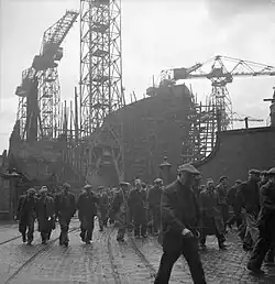 Black and white photograph of a ship under construction.