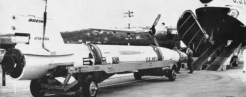 Photograph of the loading of an IM-99A missile into a Douglas C-124 cargo airplane by ramp into the plane's nose loading doors.