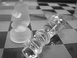 Balck and white photograph of two glass chess pieces on a chess board