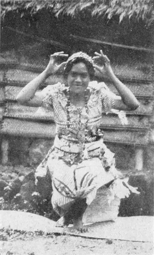 A photo of a woman posing, dressed in elaborate indigenous clothing