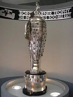 The Borg-Warner Trophy, a tall metal cup trophy topped by a figure waving a chequered flag