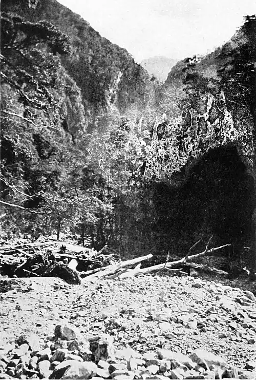 Debris and rocks in the foreground with bush covered hills in the background