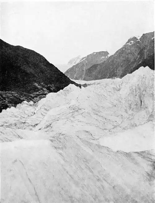 Looking up the glacier with hills on either side and mountains in the distance