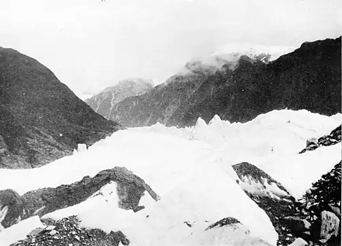 Looking up the glacier with hills on either side and mountains in the distance