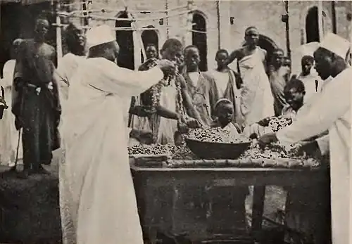 A man looking over bowls of coins among the crowd