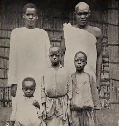 An older man with several boys standing alongside him
