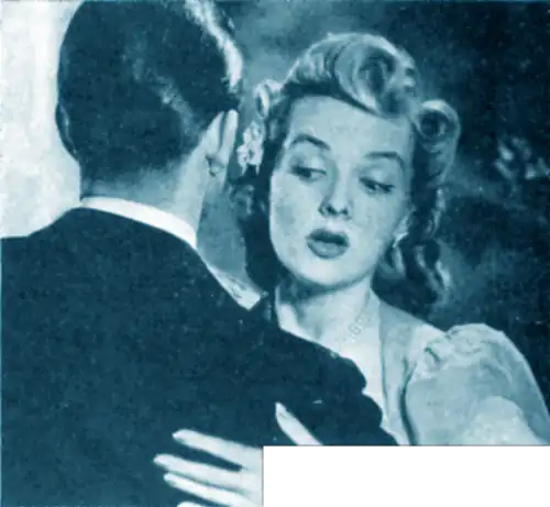 Woman embracing a suited man, while looking with concern at the dandruff on his shoulder.