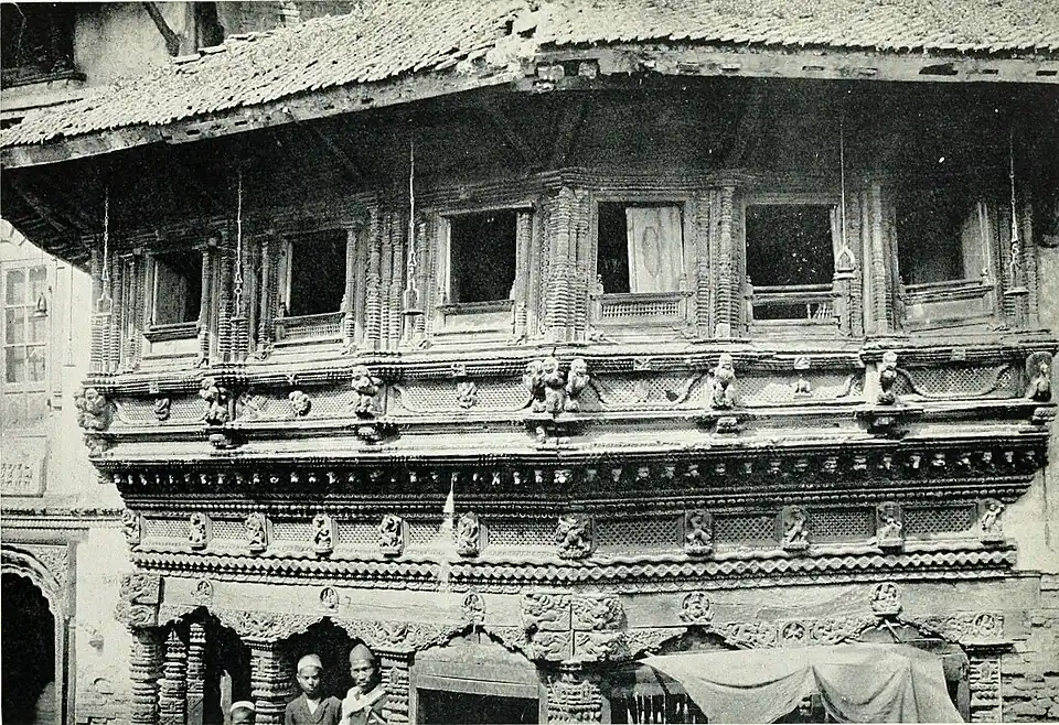 Black and white photograph of elaborate woodwork in the main street of Katmandu.